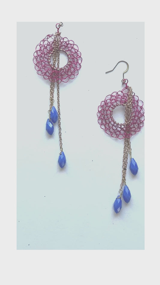 These dangling earrings are meant to be seen. The top portion consists of a hand-oven ring from which a trio of colorful crystals are suspended. A fun unique design that's easy to wear. 